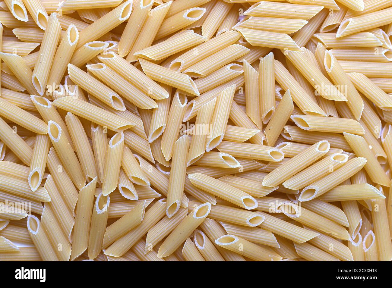 Scattered and uncooked penne texture. Pastry pattern, food background, texture idea Stock Photo