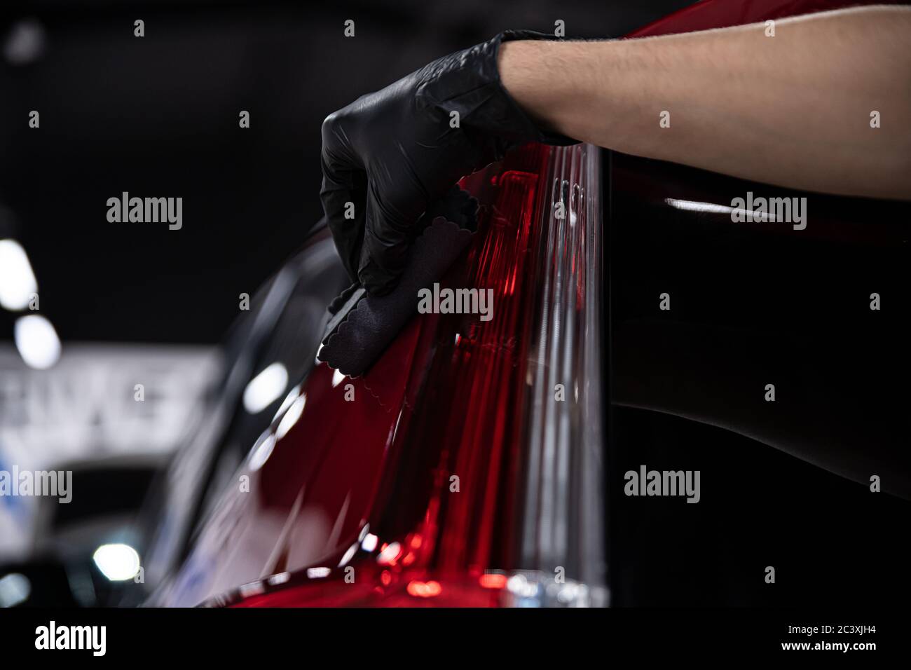 Man worker of car detailing studio applying ceramic coating on car