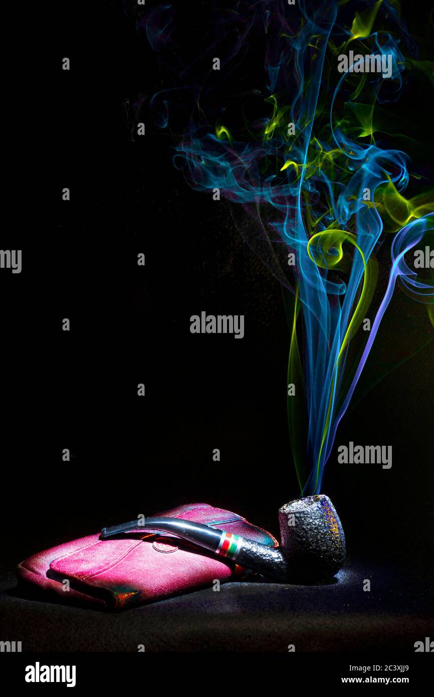 Smoking pipe. Pipe resting on its red leather case, exhales colored