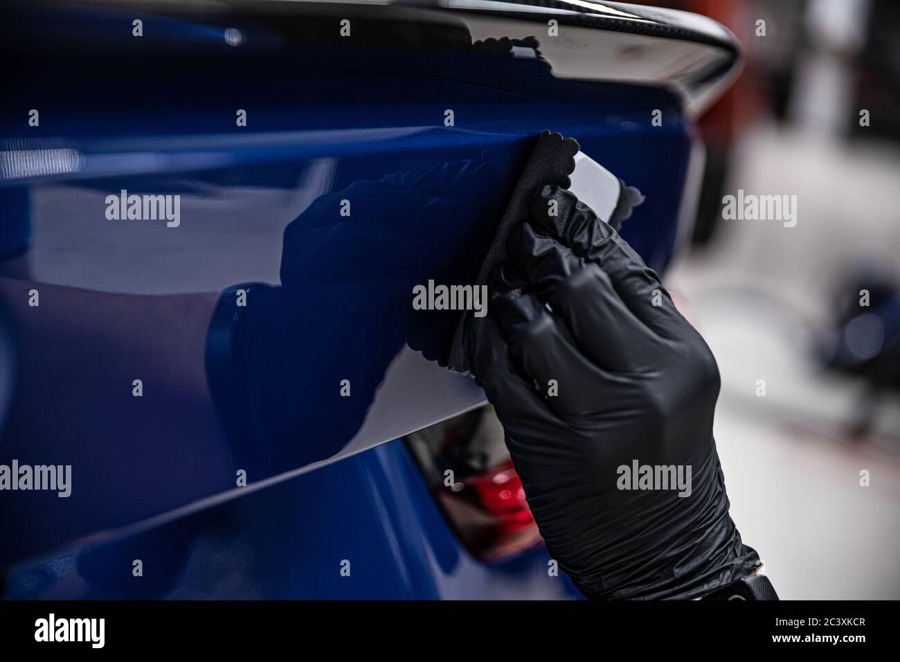 Man worker of car detailing studio applying ceramic coating on car