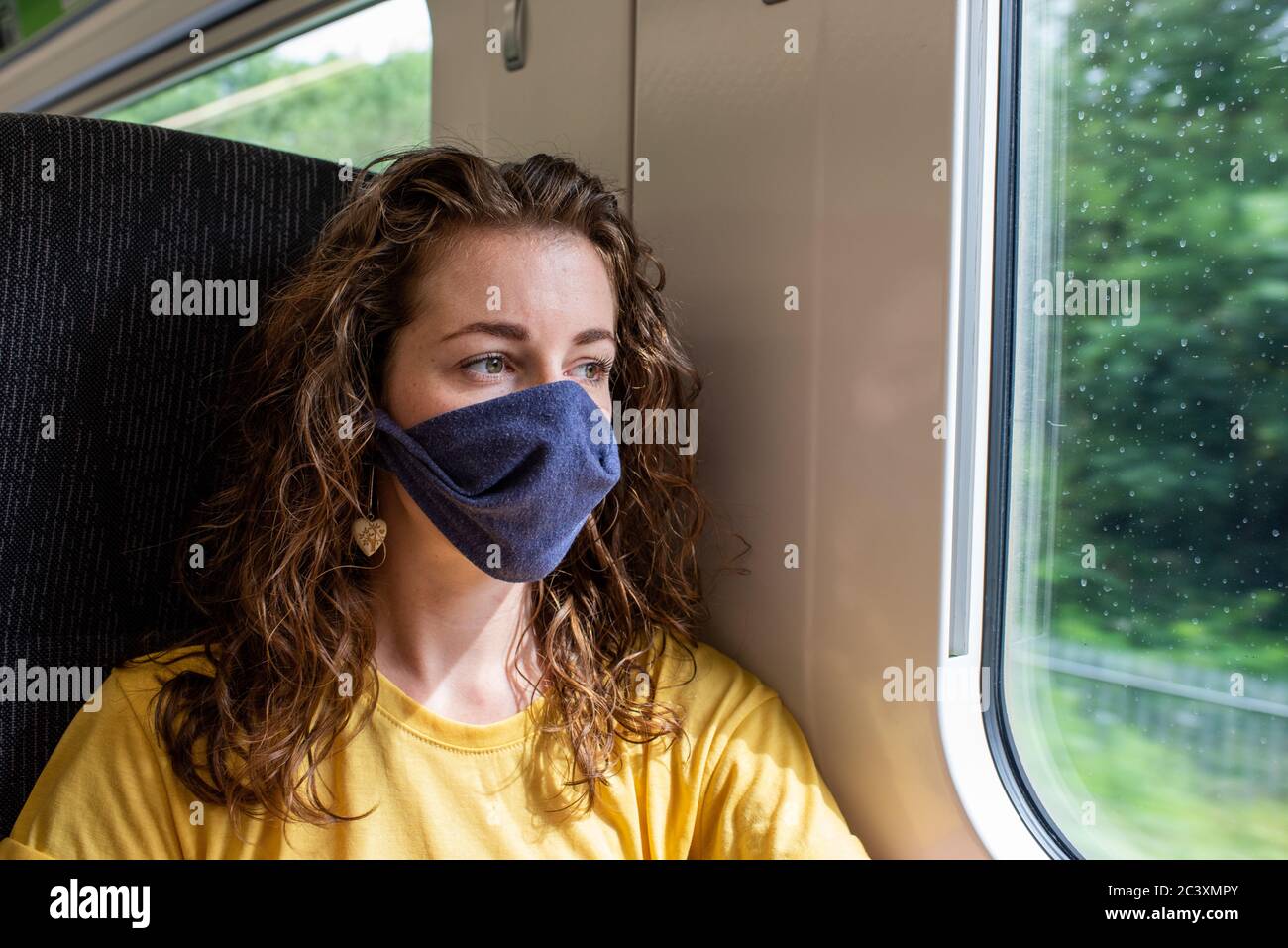 Wear a mask on the train coronavirus uk travel rail railway transport public social distance stay safe Stock Photo