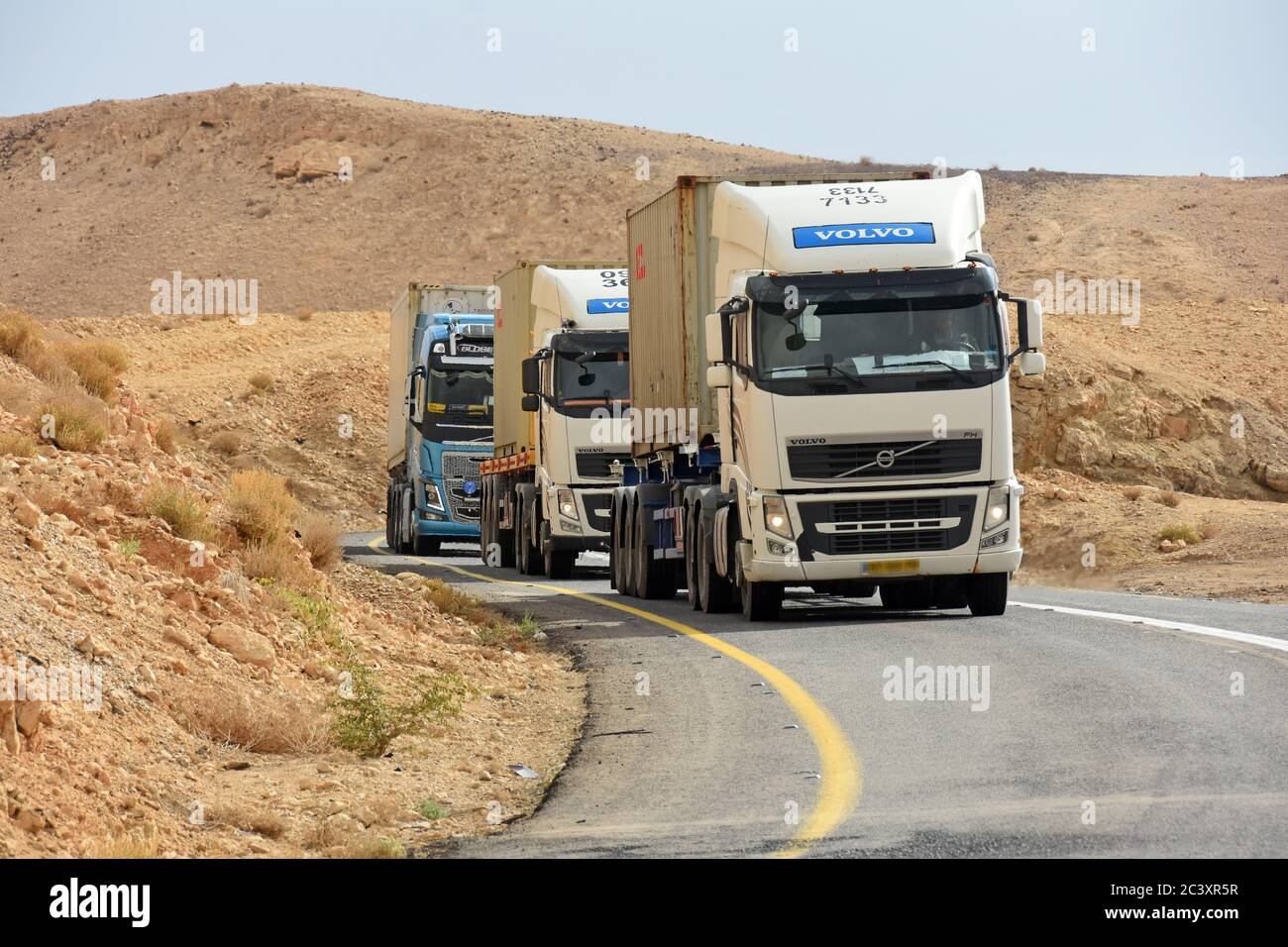 Trucks climbing up on a desert road Stock Photo