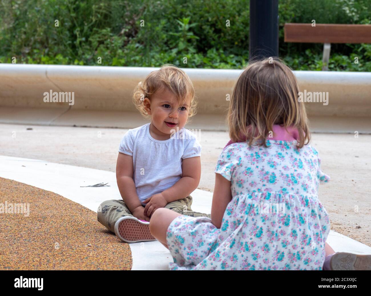 baby girl sitting with an older girl  Stock Photo