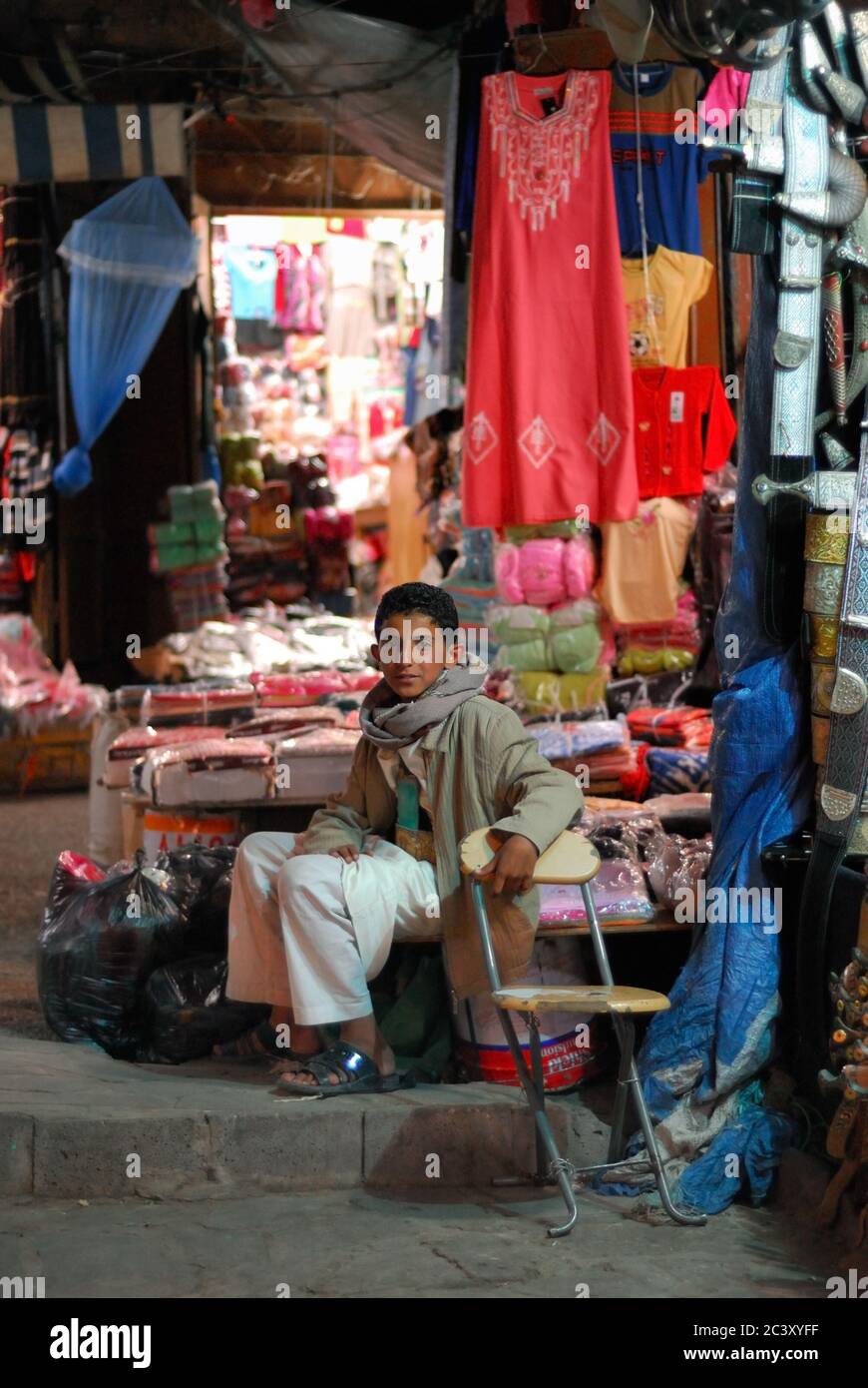 SANAA, YEMEN - MARCH 6, 2010: Unidentified young boy sells the goods at the night market. Open markets play a central role in the social-economic life Stock Photo