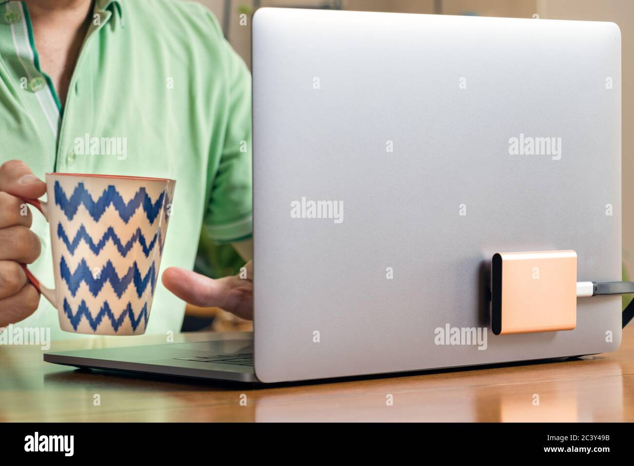 A portable SSD hard drive connected to a laptop using an usb type c port. Stock Photo