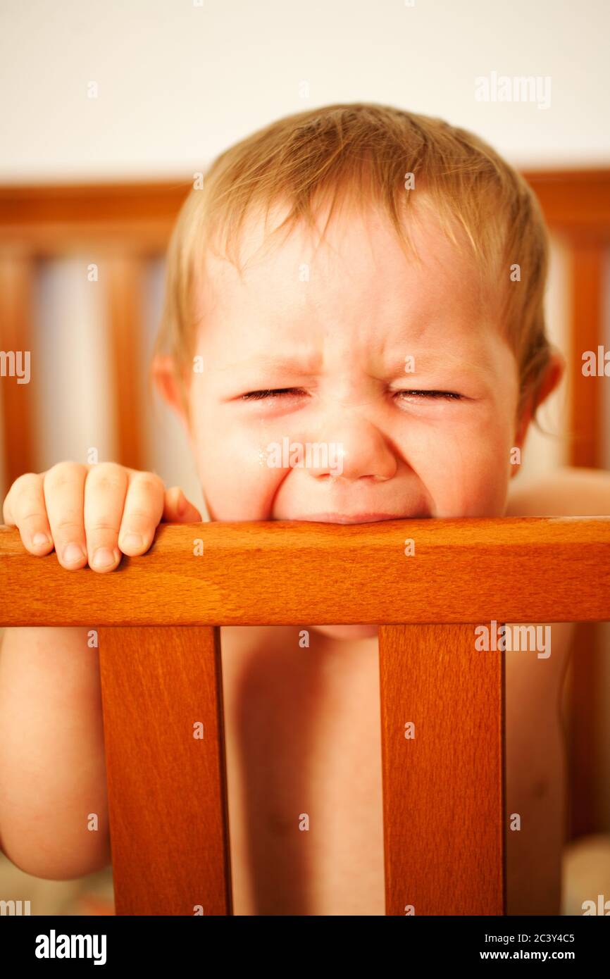 A frustrated teething baby cries to get out of her crib Stock Photo Alamy