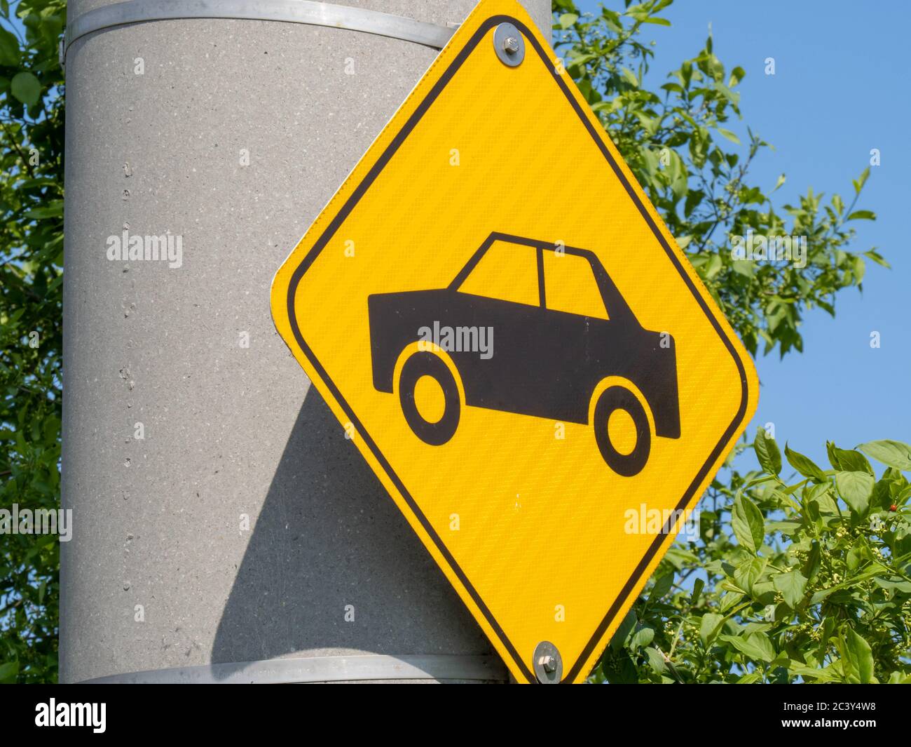 a yellow diamond sign indicating caution car crossing Stock Photo Alamy