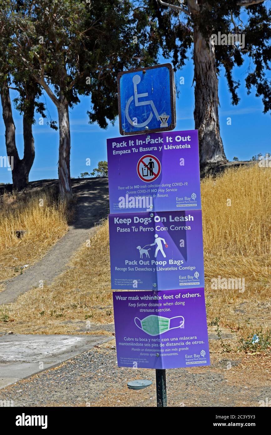Alameda Creek Trail Stables Staging Area, rules signs, pack it in- pack it out, keep dogs on leash, wear masks within 6 feet of others, in English and Spanish California Stock Photo