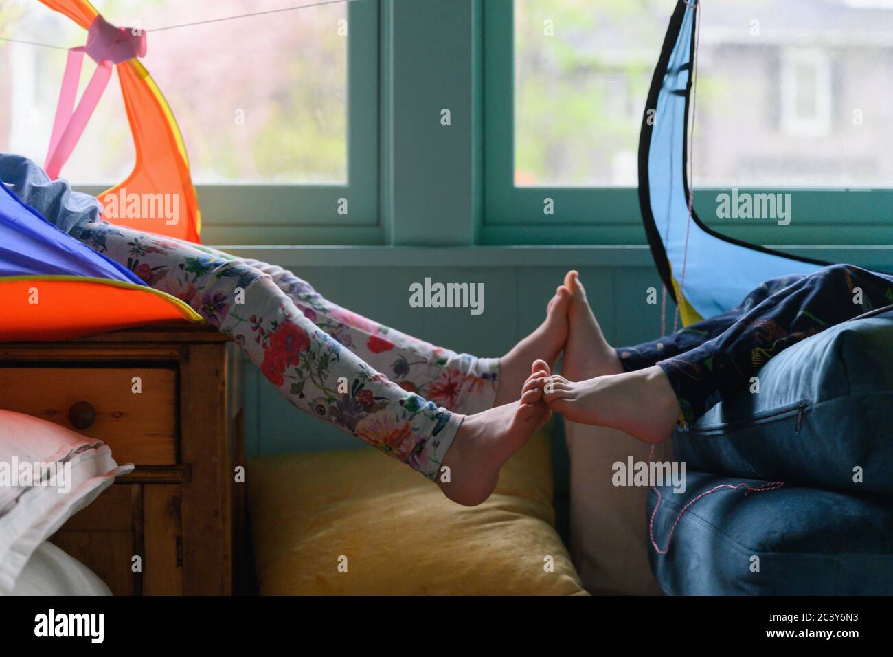 Brother (4-5) and sister (6-7) touching feet out of tents in playroom Stock  Photo - Alamy