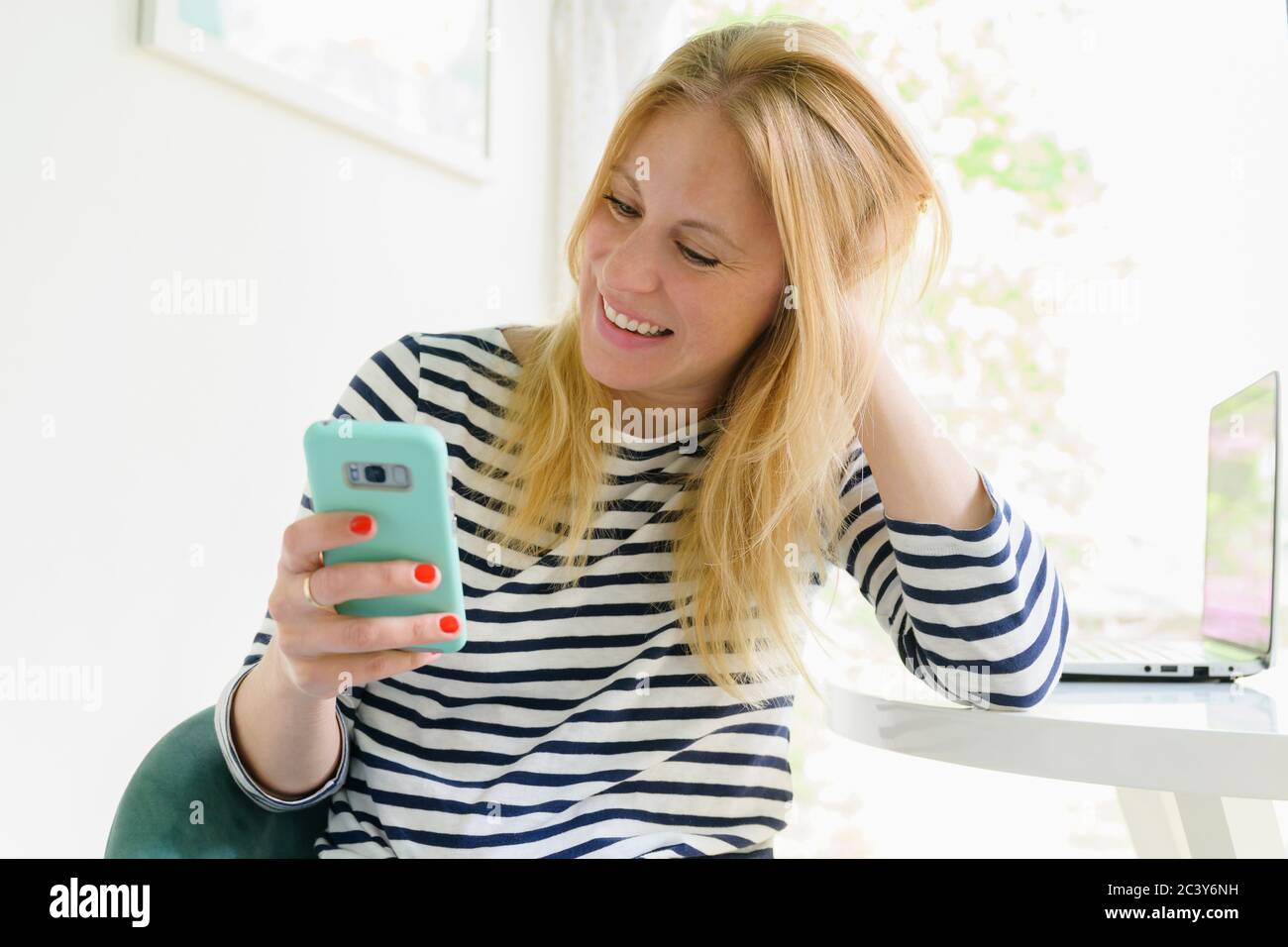 Smiling woman using smart phone Stock Photo
