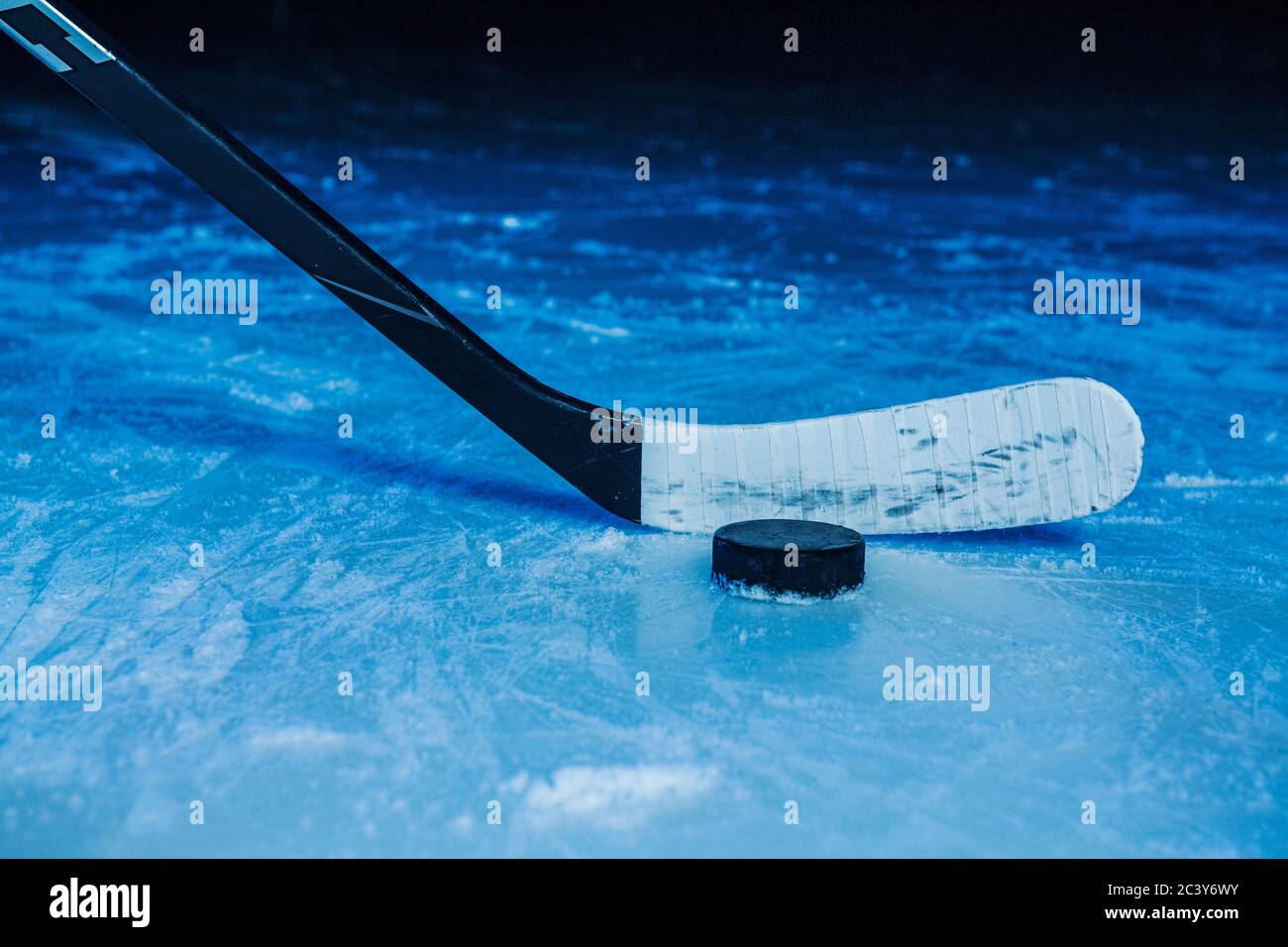 Hockey stick and puck in a cloud of ice chips stock photo - OFFSET
