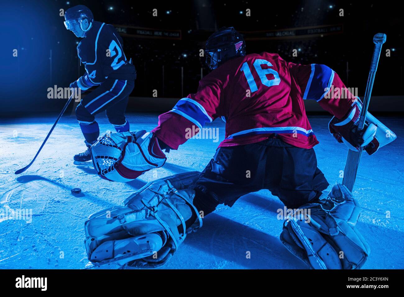 Hockey goalie in defensive position against forward Stock Photo