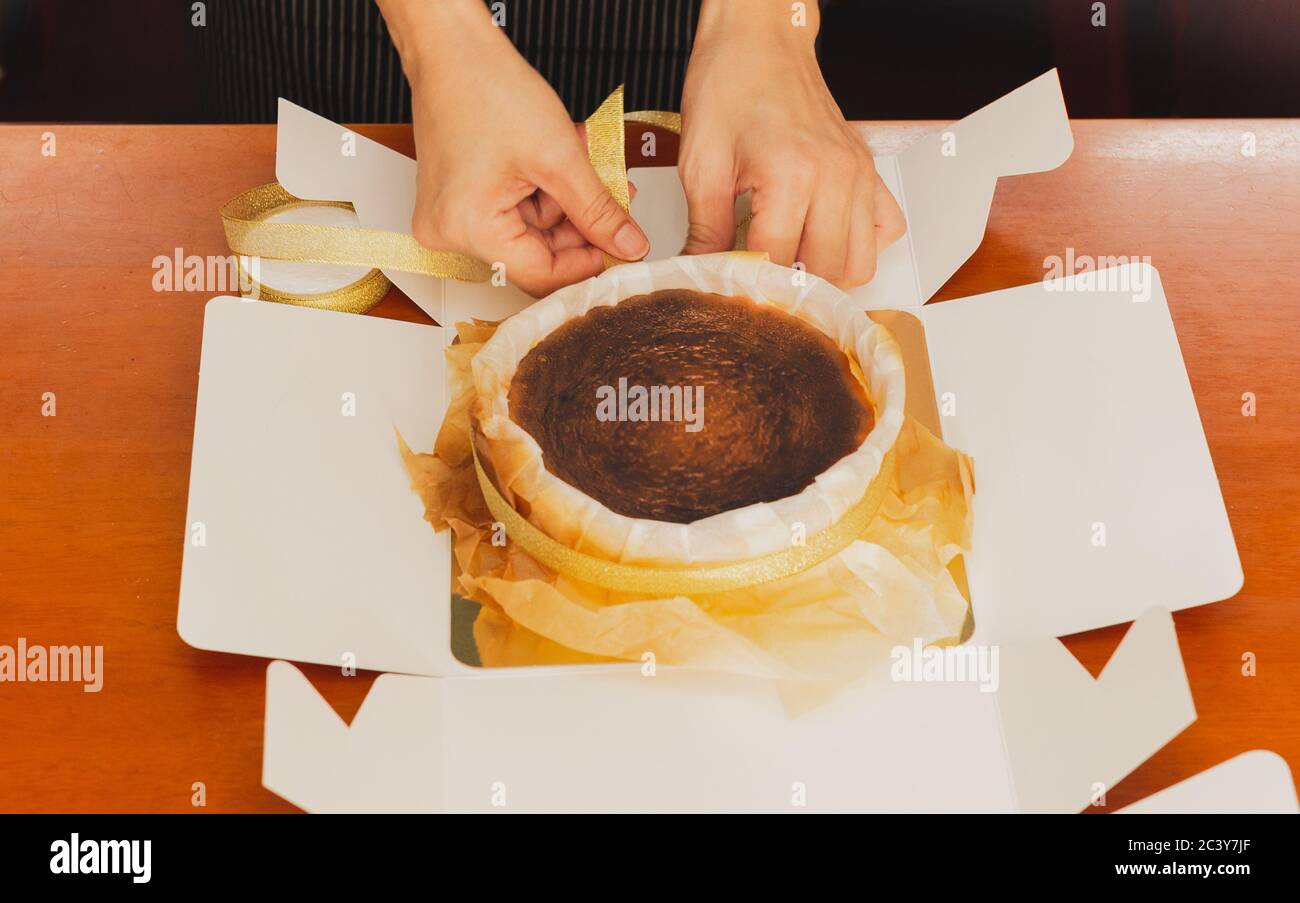 Woman hand packing cake in cardboard box, food order work at home in ...