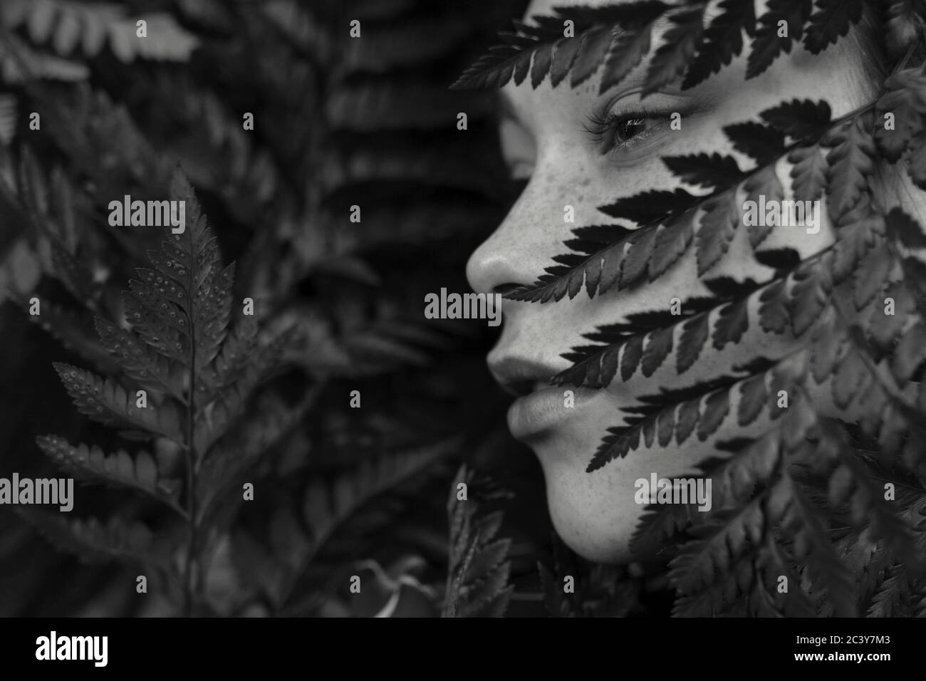 Face of young woman covered with plants Stock Photo