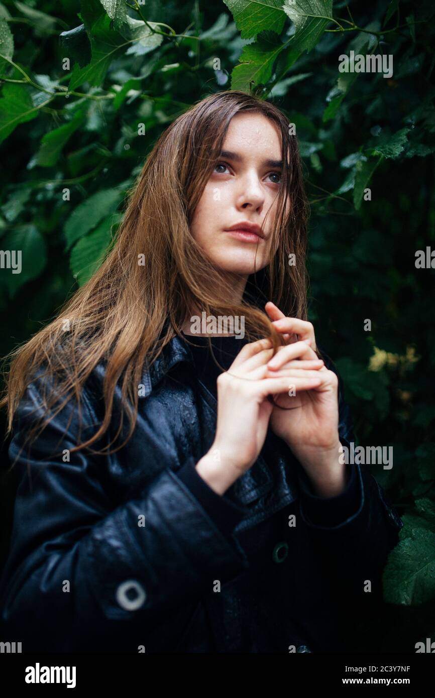 Portrait of young woman standing by tree Stock Photo - Alamy