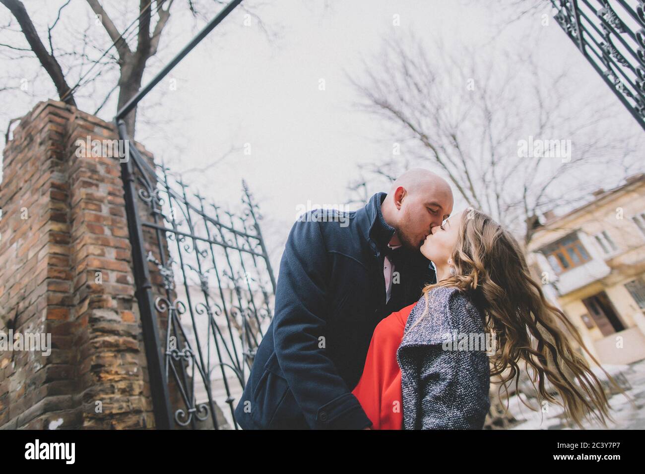 Newlywed couple kissing on street Stock Photo