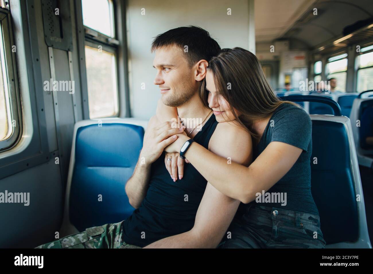Young couple embracing in train Stock Photo