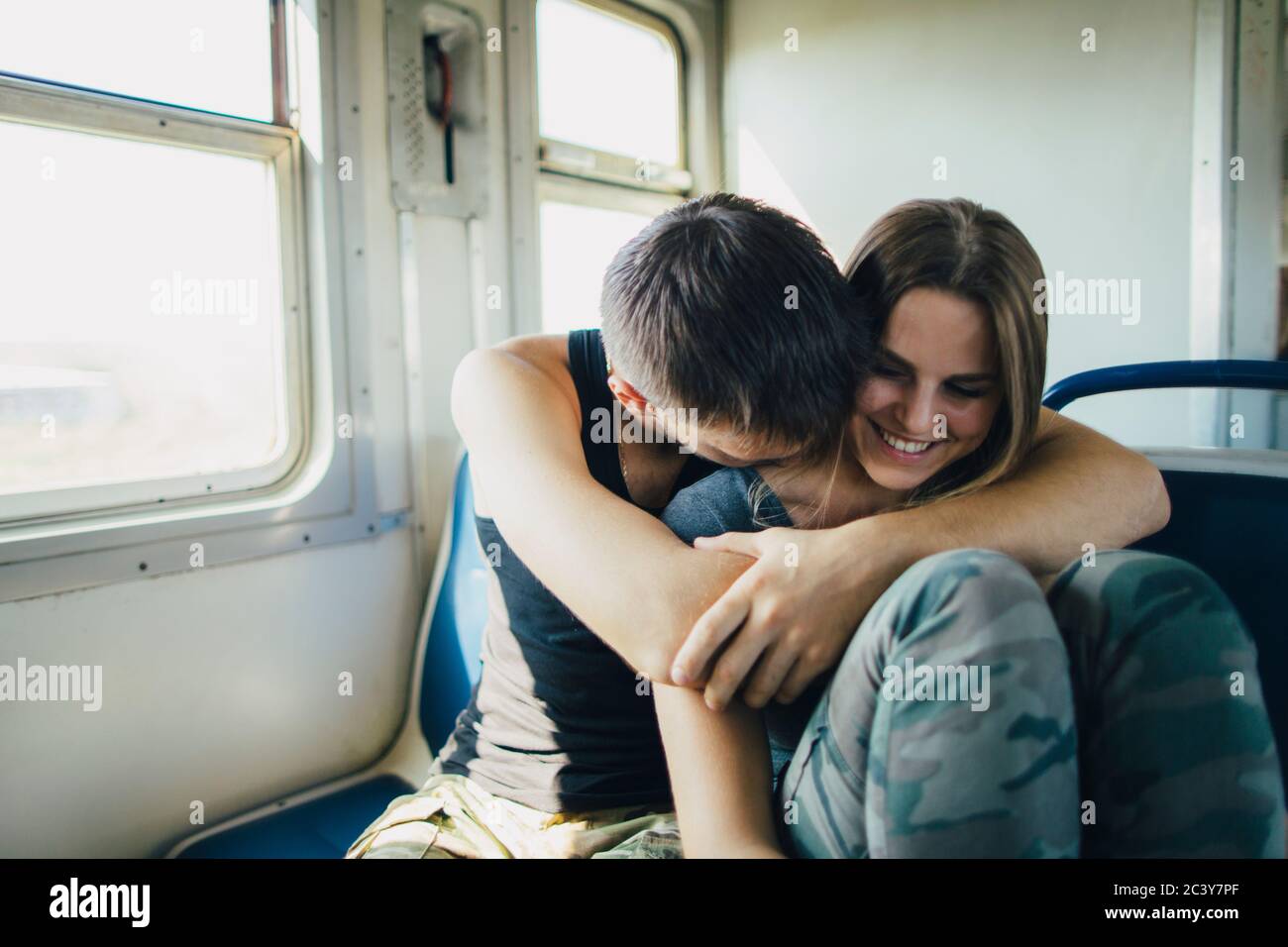 Young couple embracing in train Stock Photo