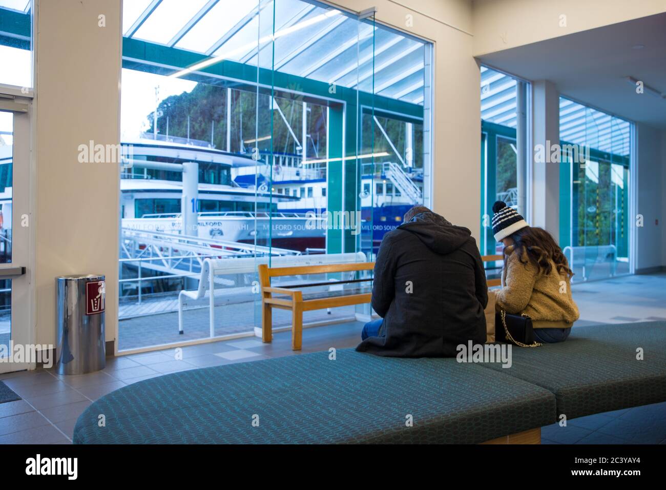 Milford Sound, Fiordland, New Zealand, June 19 2020: Two New Zealand tourists in the ferry terminal at Milford Sound, waiting to go on a cruise Stock Photo