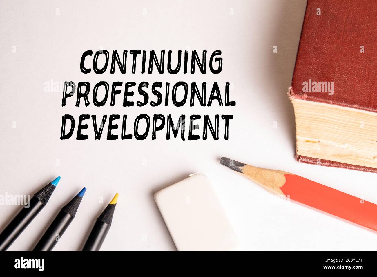 CONTINUING PROFESSIONAL DEVELOPMENT concept. Book, pencils and eraser ...