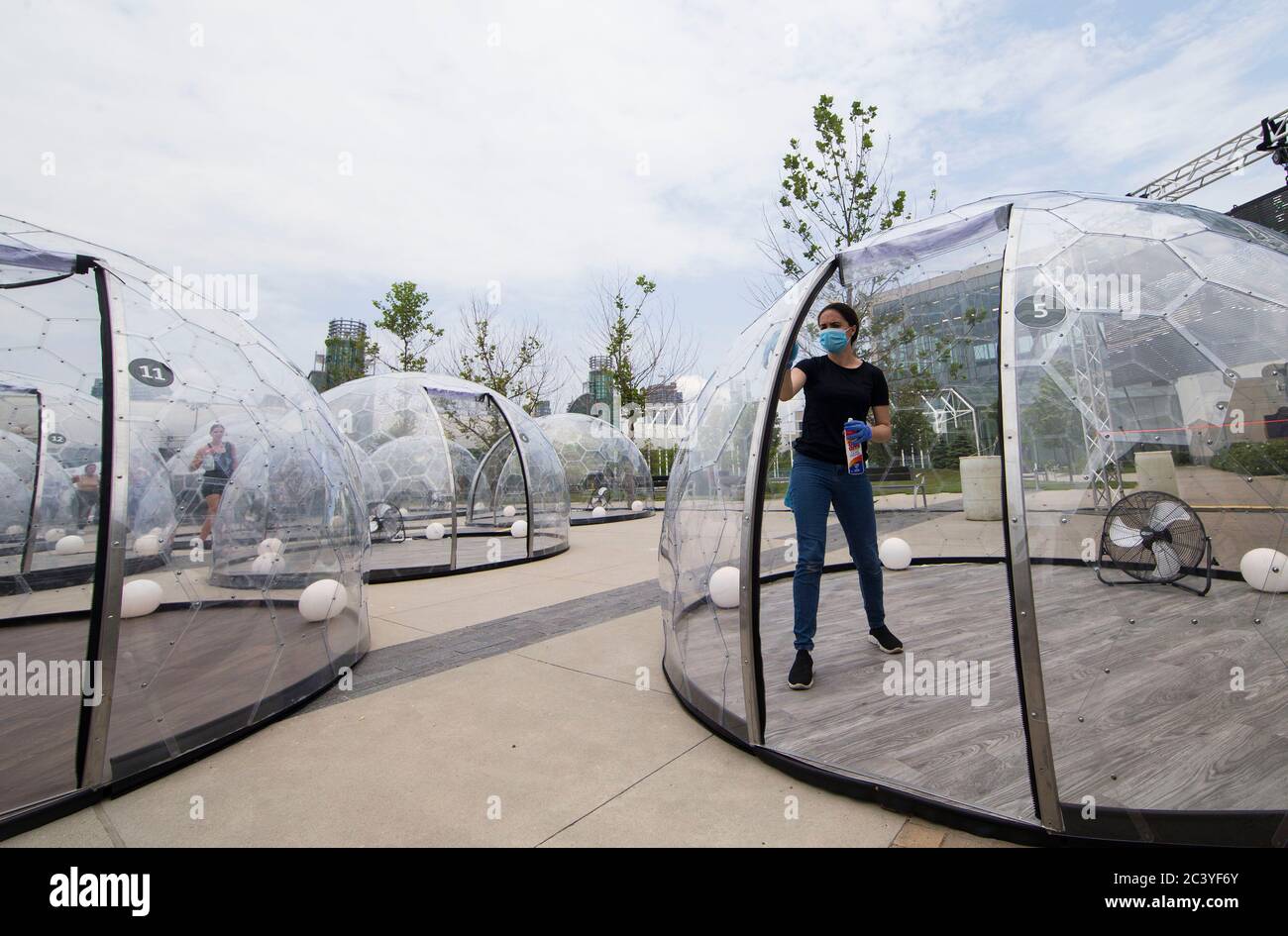 Toronto, Canada. 22nd June, 2020. A staff member (R) cleans a yoga dome  after use in Toronto, Canada, on June 22, 2020. A new pop-up event called Hot  Yoga has been held