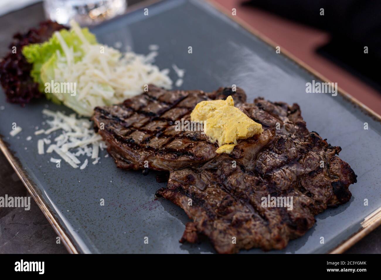 Delicious grilled steak on a blue ceramic stoneware. Stock Photo