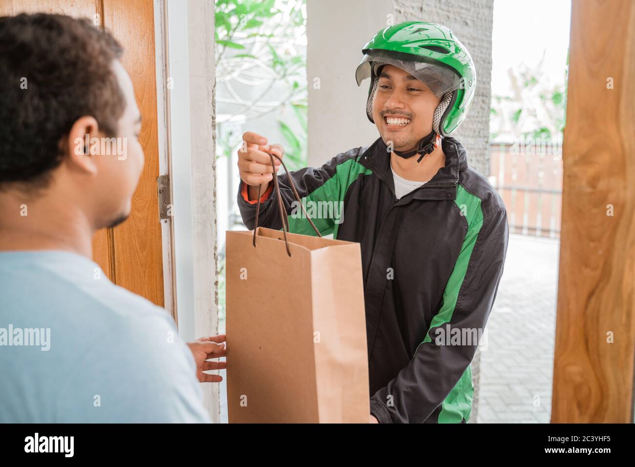 man delivery service uber send shopping bag to customer at home Stock Photo Alamy