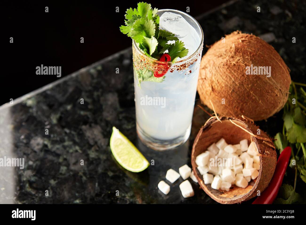 Cocktail with rum, coconut syrup, cilantro, lime and red chilli pepper