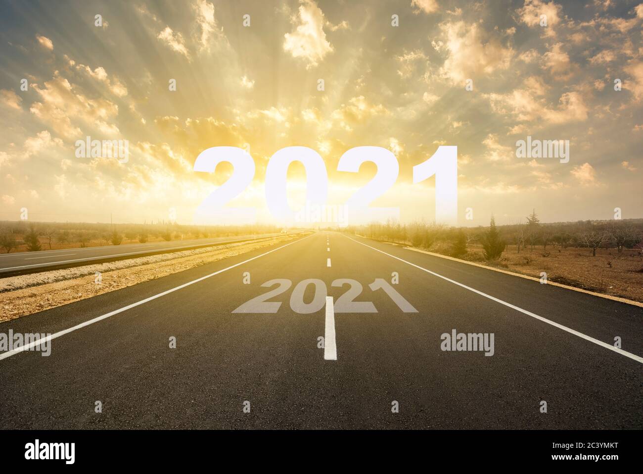 The word 2021 behind asphalt road at sunset. Concept for vision year 2021. New Year concept Stock Photo