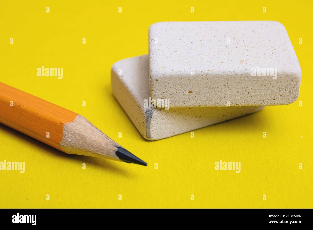 Two erasers and pencil on a yellow background Stock Photo