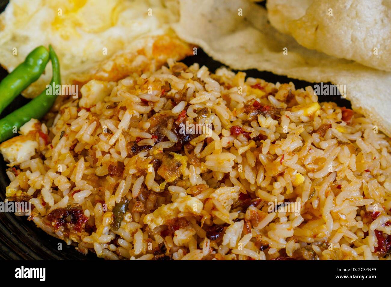 Spicy fried rice with dried chilli with fried egg and fish cracker. Stock Photo