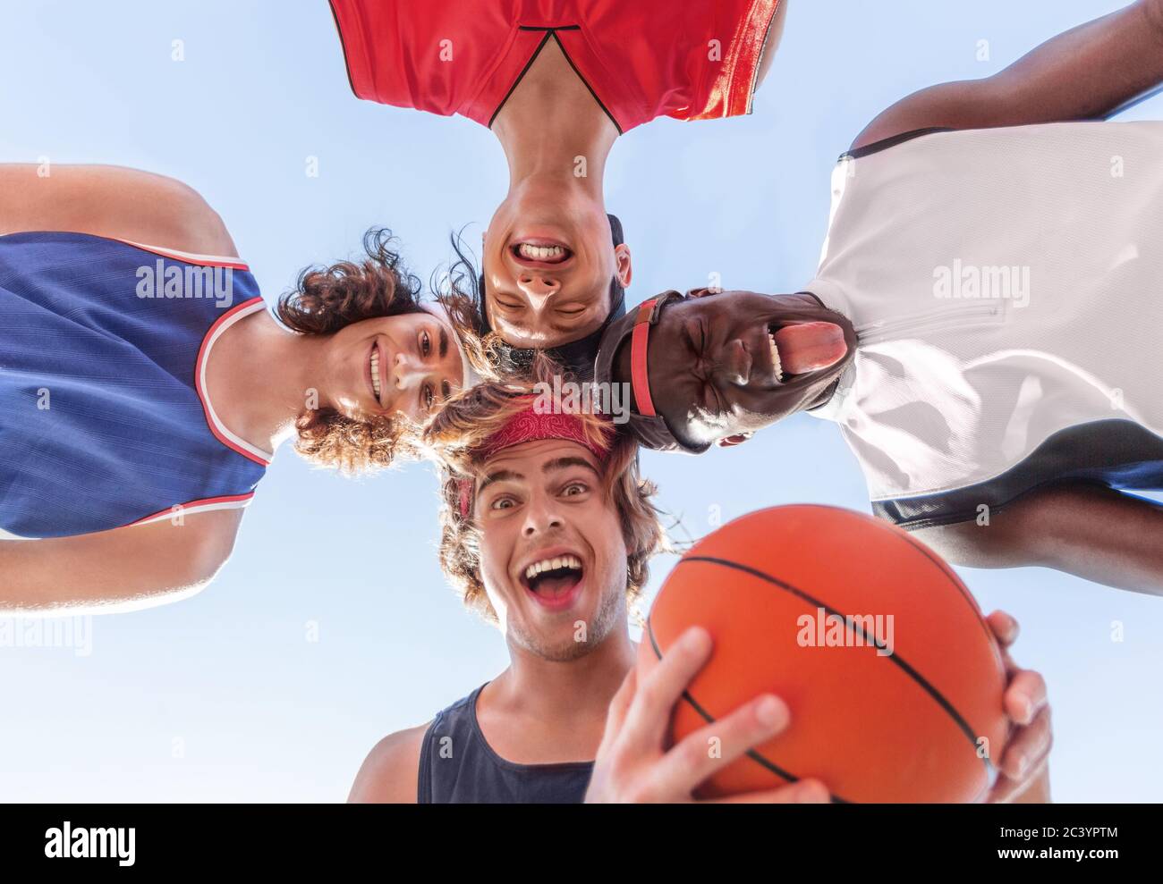 Diverse basketball players putting their heads together and making