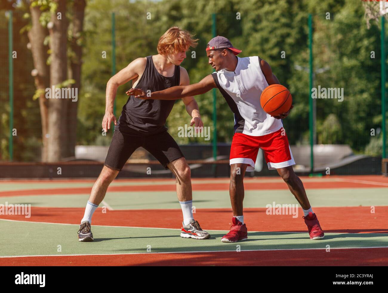Professional basketball players on outdoor court during friendly game Stock Photo