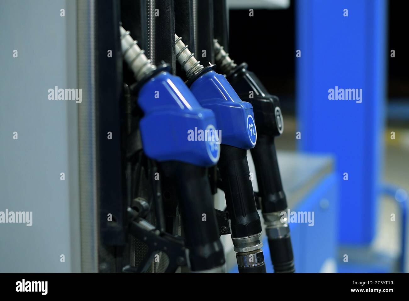 refueling guns hang at a gas station in the evening Stock Photo