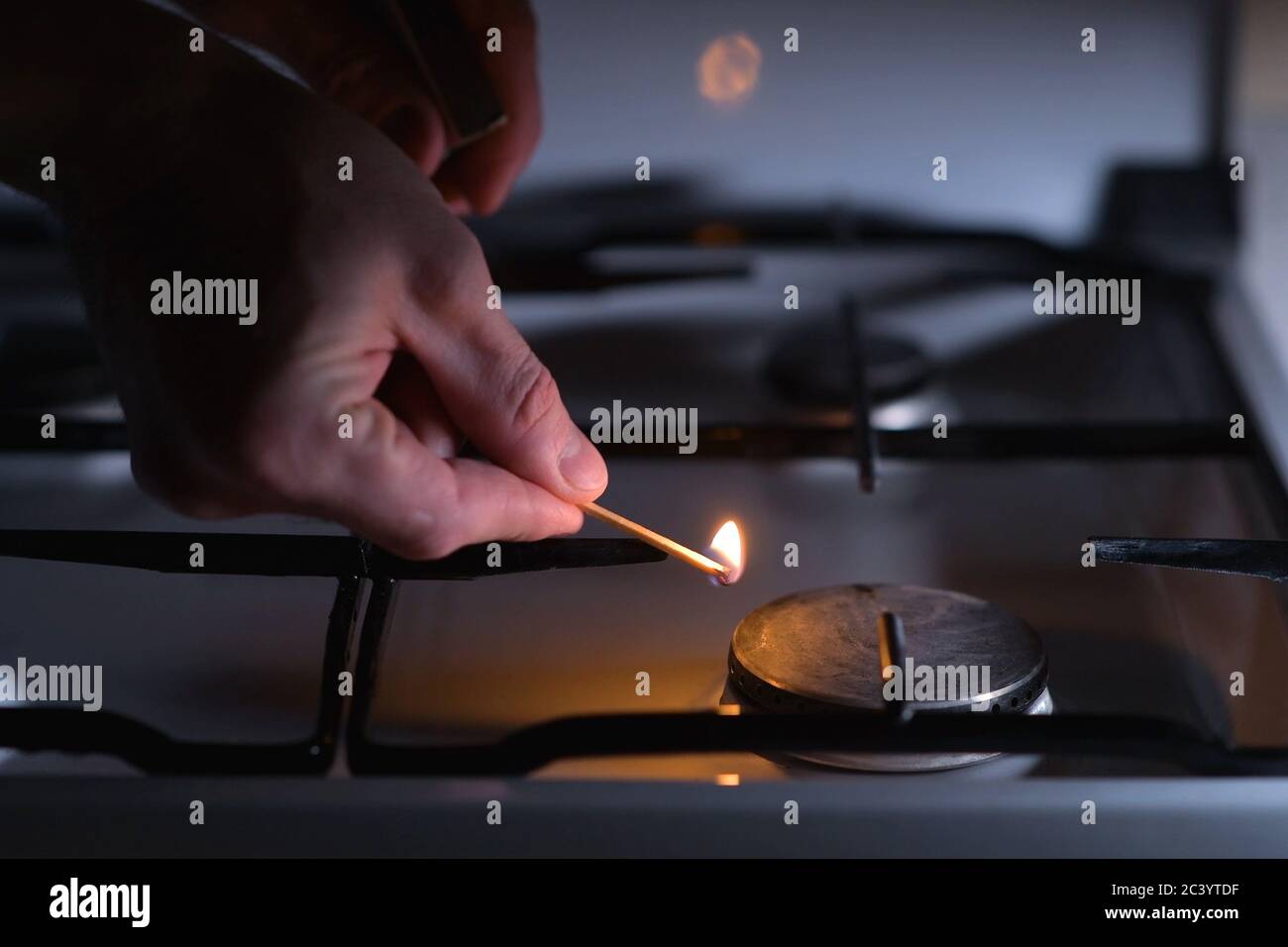 A man going to light a gas stove with a match Stock Photo Alamy