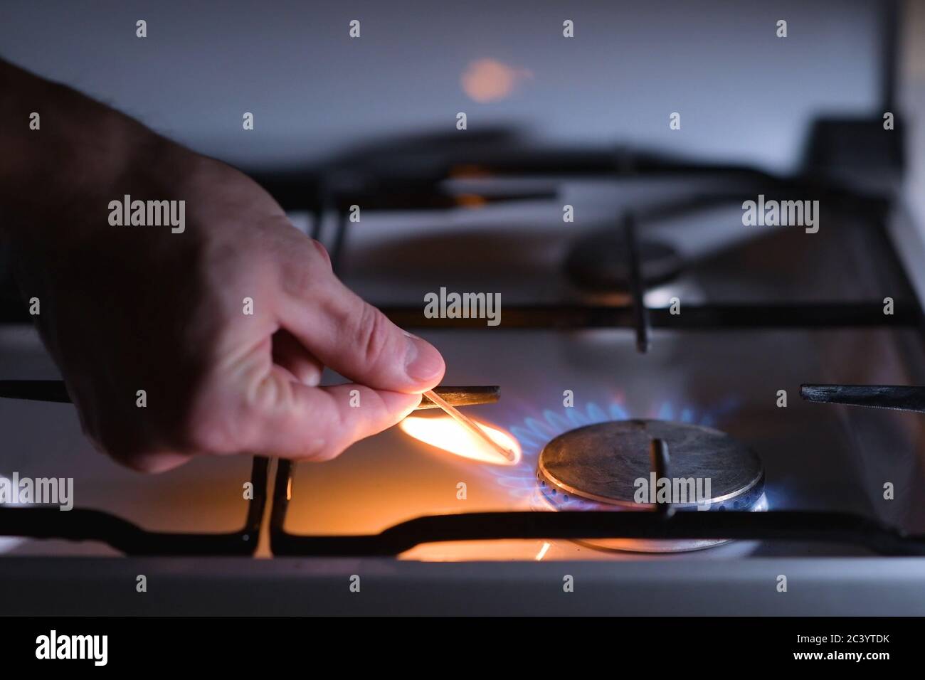 A man lights a gas stove with a match Stock Photo Alamy