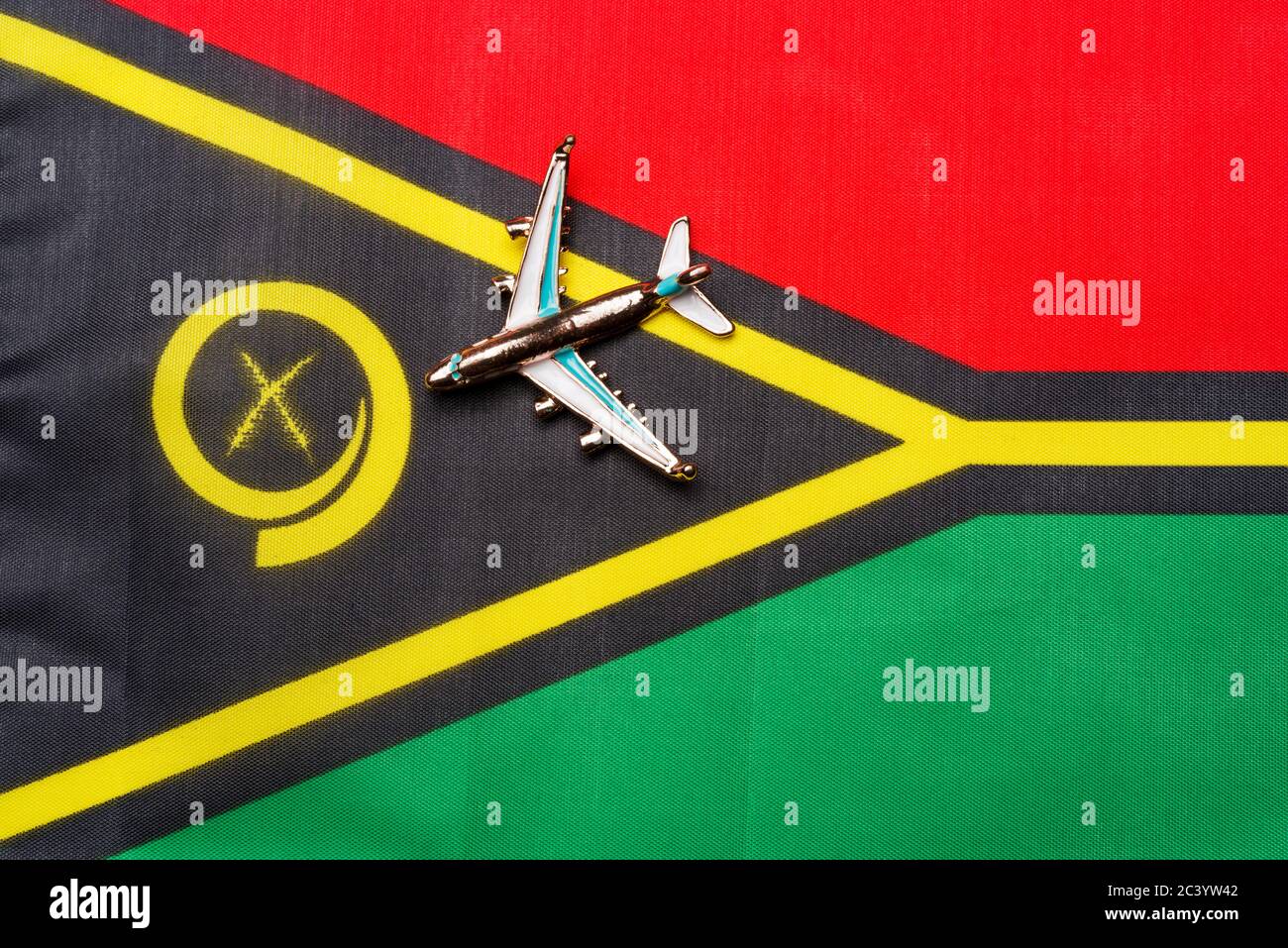 Plane over the flag of Vanuatu the concept of travel and tourism. Toy plane on a flag in the background. Stock Photo