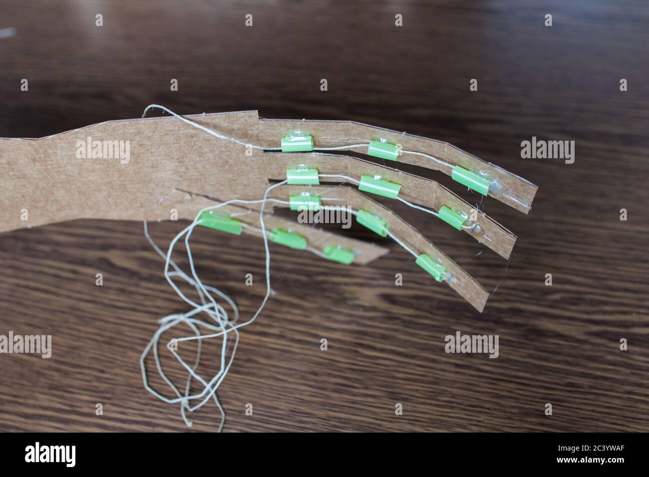 Various cardboard arm DIY for educational STEM activity with kids and red stapler on the table. Robotics for education Stock Photo