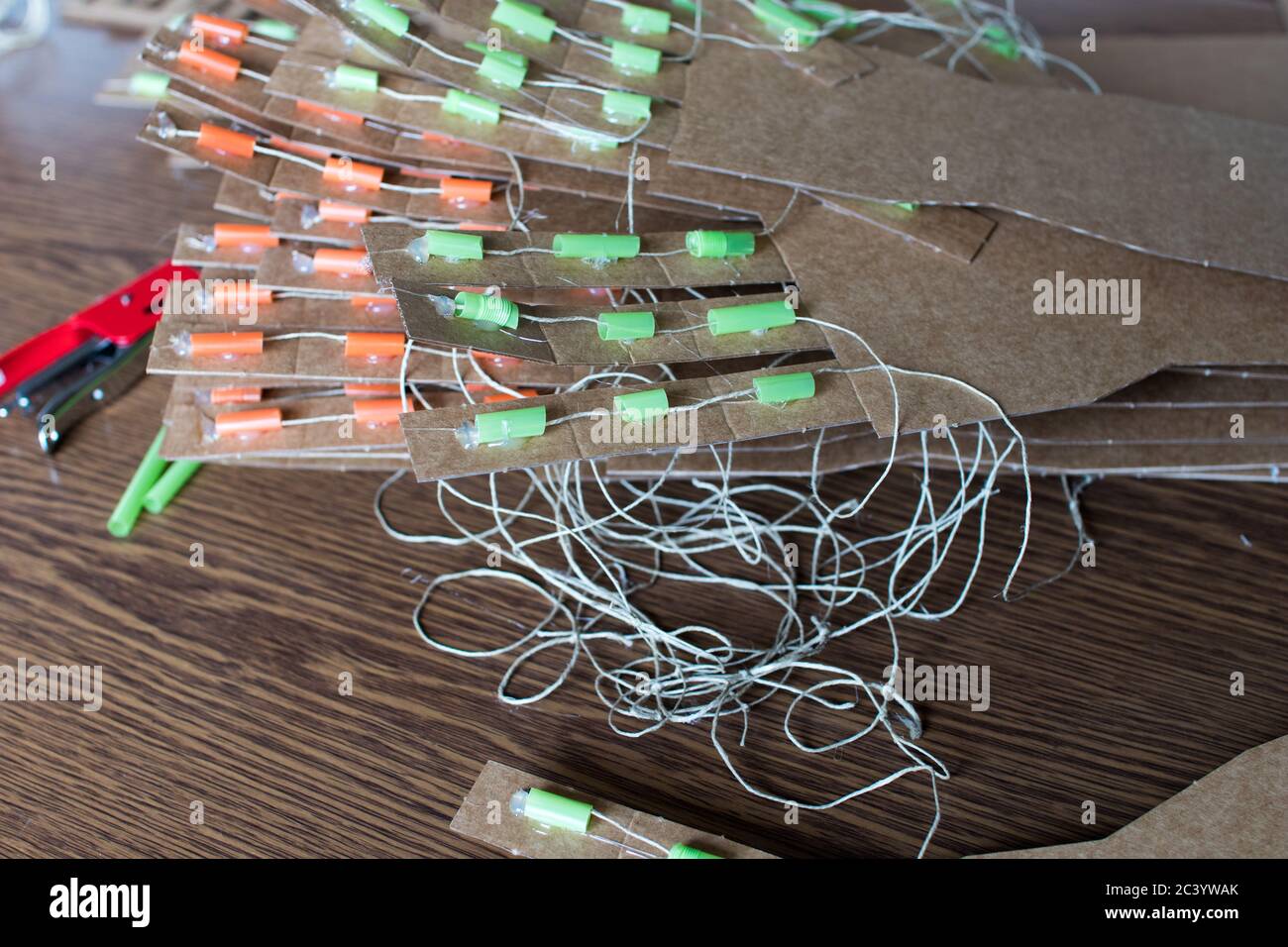 Various cardboard arm DIY for educational STEM activity with kids and red stapler on the table. Robotics for education Stock Photo