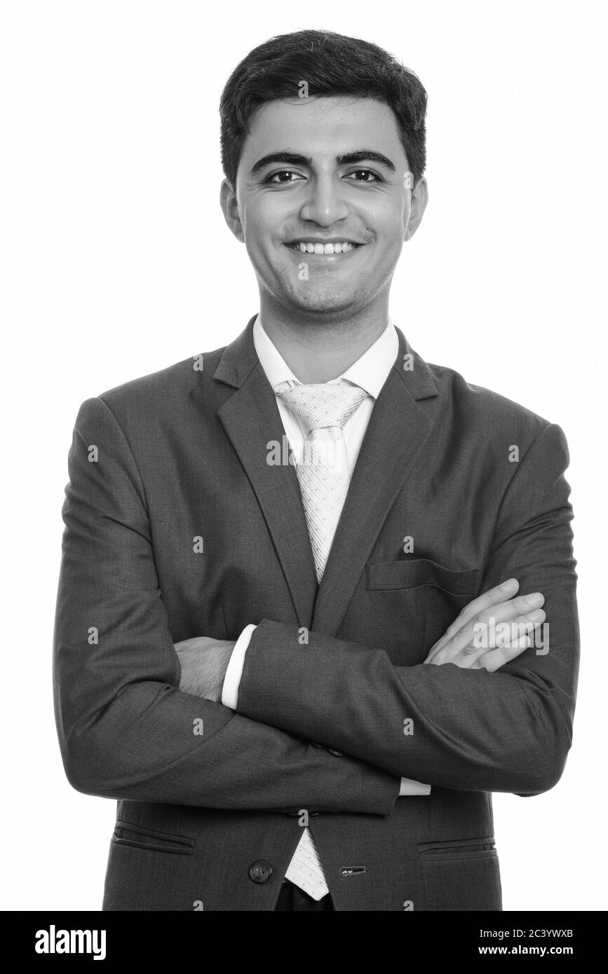 Portrait of happy young handsome Persian businessman smiling with arms ...