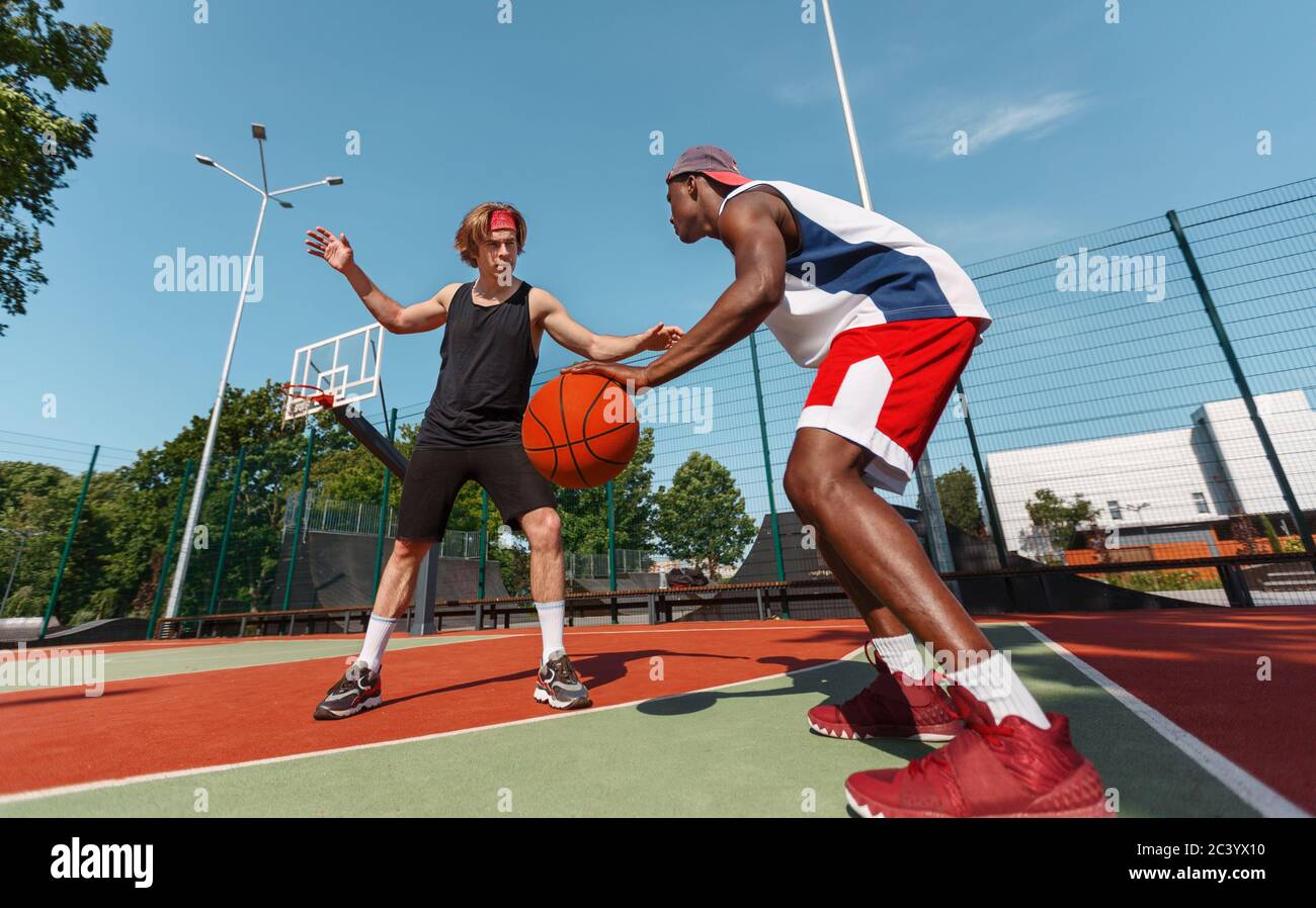 Two young basketball players in action at outdoor sports court Stock Photo