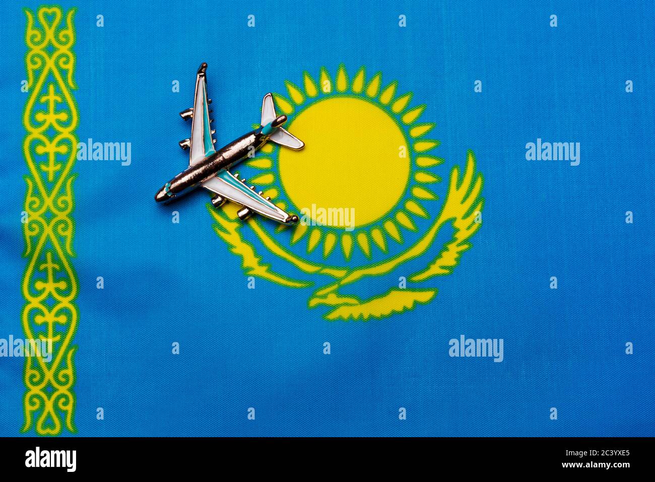 Plane over the flag of Kazakhstan travel concept. Toy plane on a flag in the background. Stock Photo