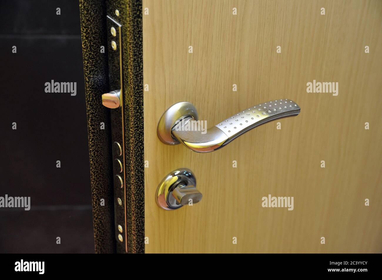 Modern style doorknob on a wooden door. Door lock Stock Photo