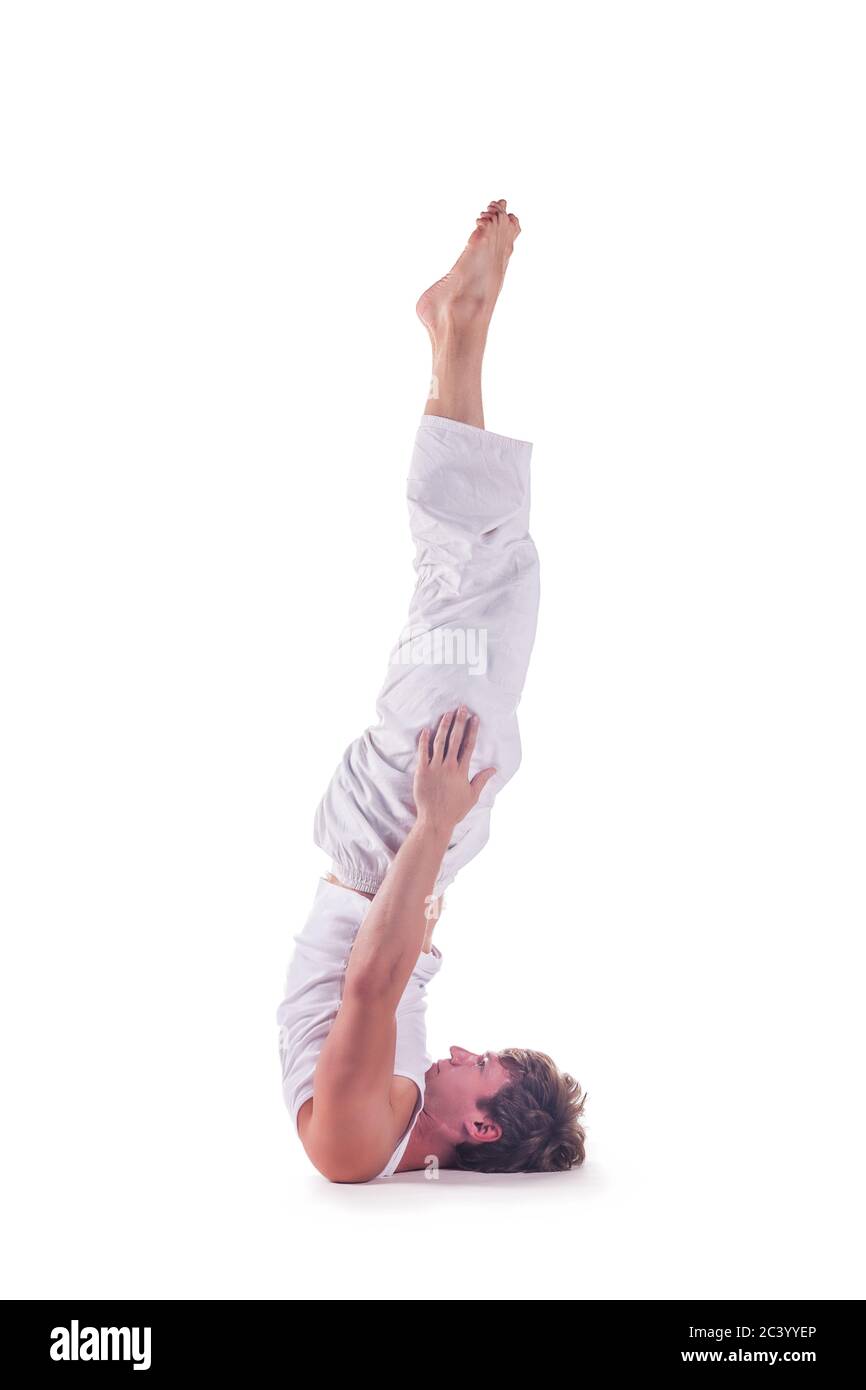 Man practicing yoga doing the ' head stand pose without hands '  against white background. Niralamba shirshasana Stock Photo