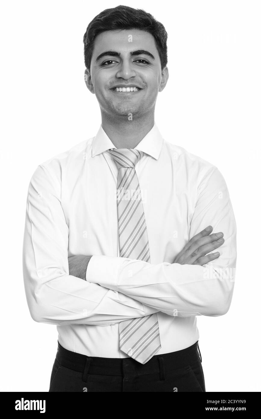 Portrait of happy young handsome Persian businessman smiling with arms ...