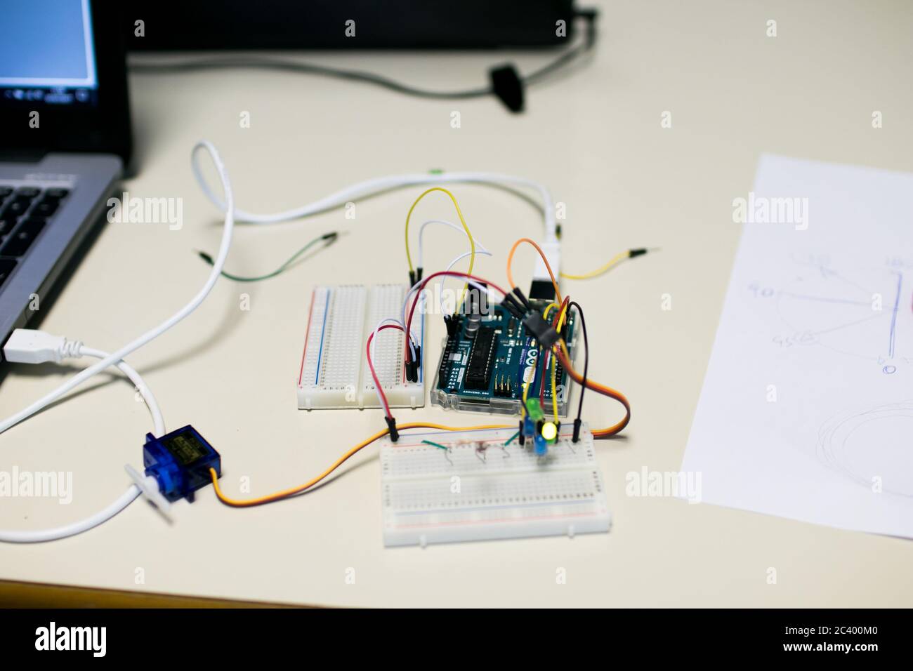 Circuit for a servomotor built for educational purposes. A programmed microcontroller manages the position of a servomotor, on a sheet are indicated t Stock Photo