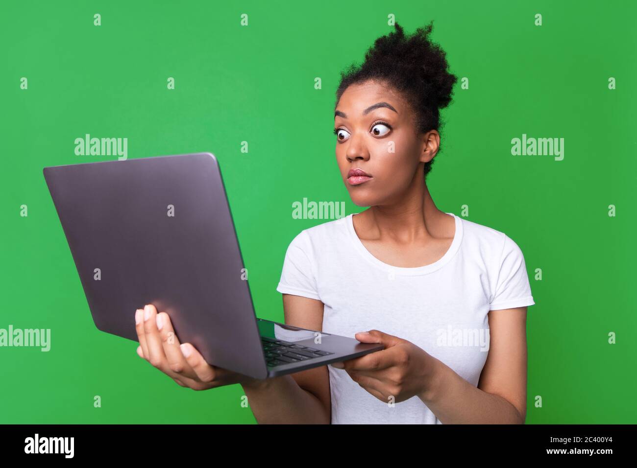 Excited black girl feeling surprised holding laptop Stock Photo