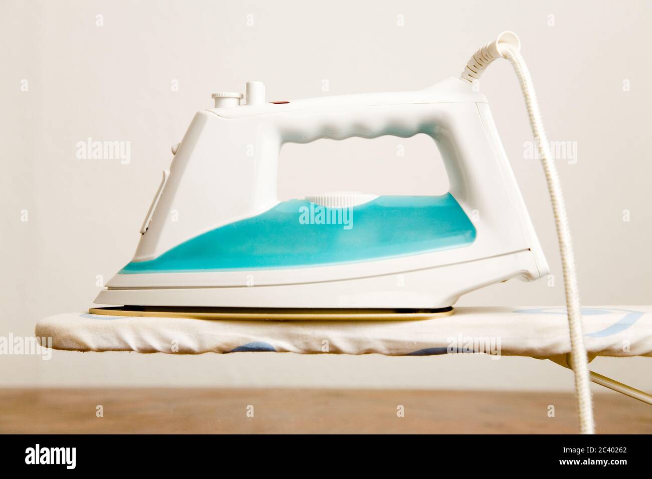 Bright iron stands on an ironing board Stock Photo Alamy