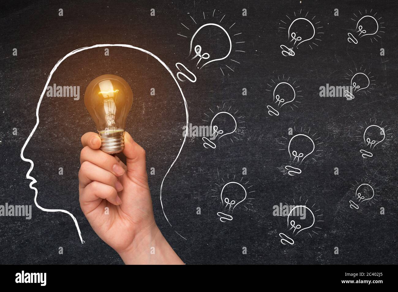 Ideas And Creativity. Hand Holding Glowing Light Bulb Over Sketched ...