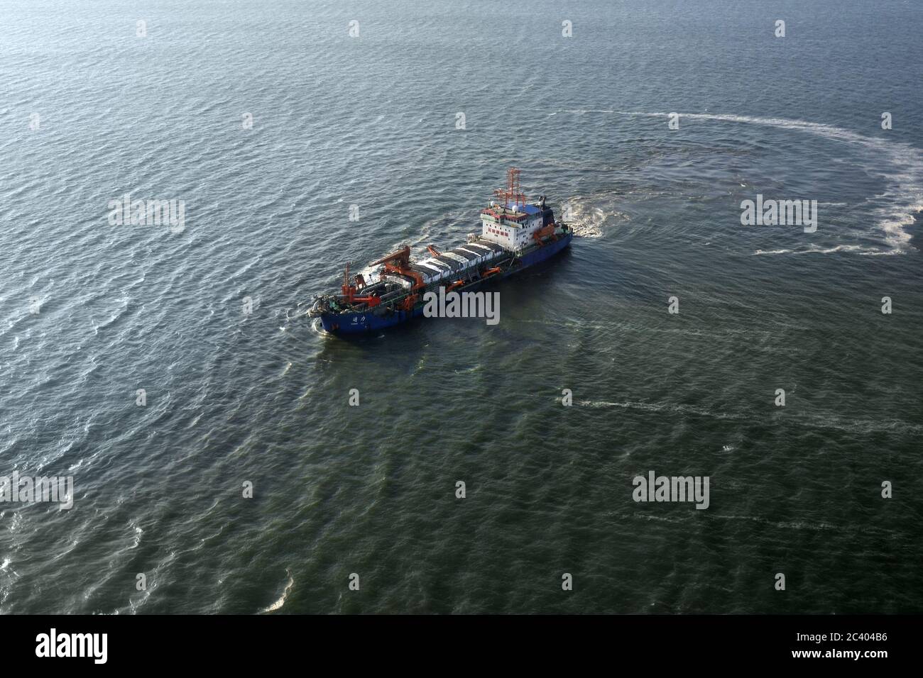 NAMIBIA - JAN 30. 2016: Chinese cargo ship Tong Li in the Atlantic Ocean off the coast of Africa near Luderitz port. Aerial view. Chinese expansion on Stock Photo
